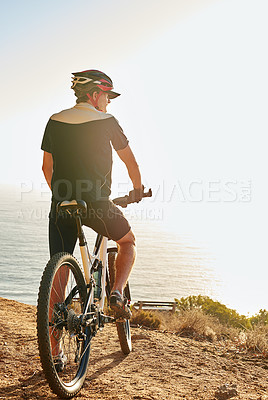 Buy stock photo Shot of a man admiring the view from a hilltop while out on a bike ride
