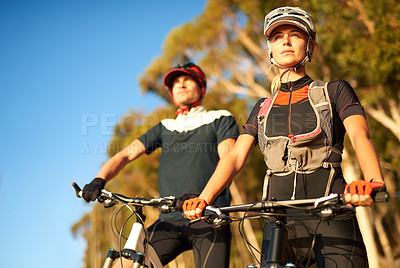Buy stock photo Shot of a young couple out mountain biking