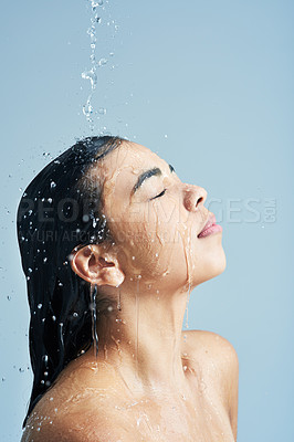 Buy stock photo Shot of a young woman having a shower against a blue background