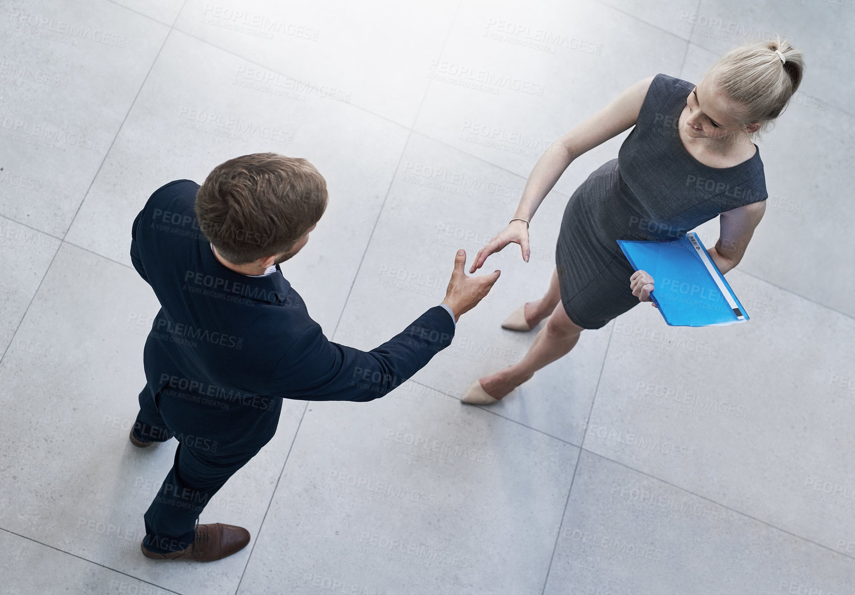 Buy stock photo High angle shot of two unrecognizable businesspeople shaking hands in a corporate office