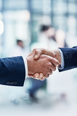 Buy stock photo Cropped shot of two unrecognizable businesspeople shaking hands in a corporate office