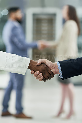 Buy stock photo Cropped shot of two unrecognizable businesspeople shaking hands in a corporate office
