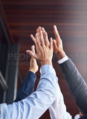 Buy stock photo Cropped shot of a group of unidentifiable businesspeople high fiving in the office