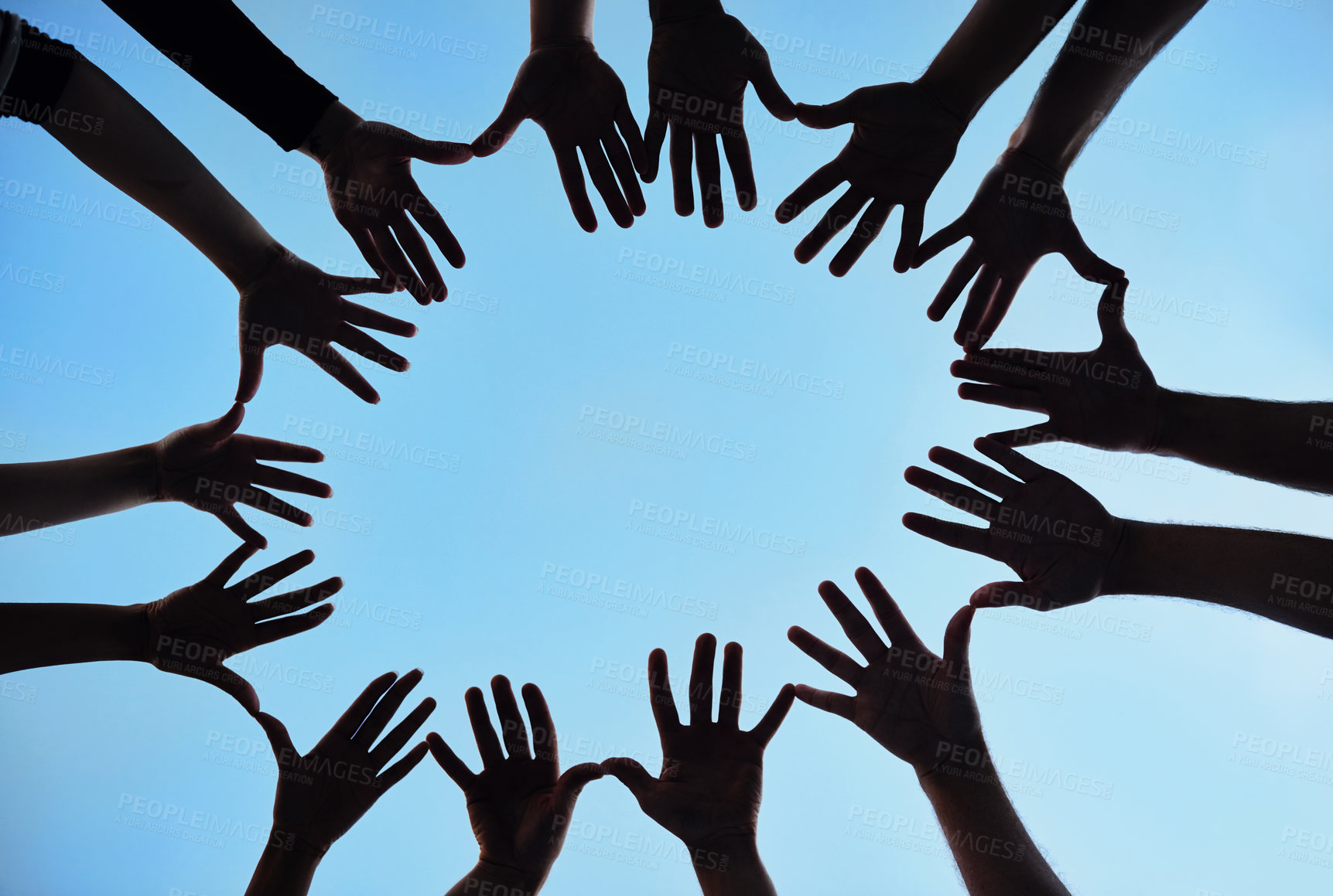 Buy stock photo Silhouetted shot of a group of unidentifiable people making a star shape with their hands
