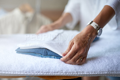 Buy stock photo Closeup of a woman folding some clothes that have been ironed