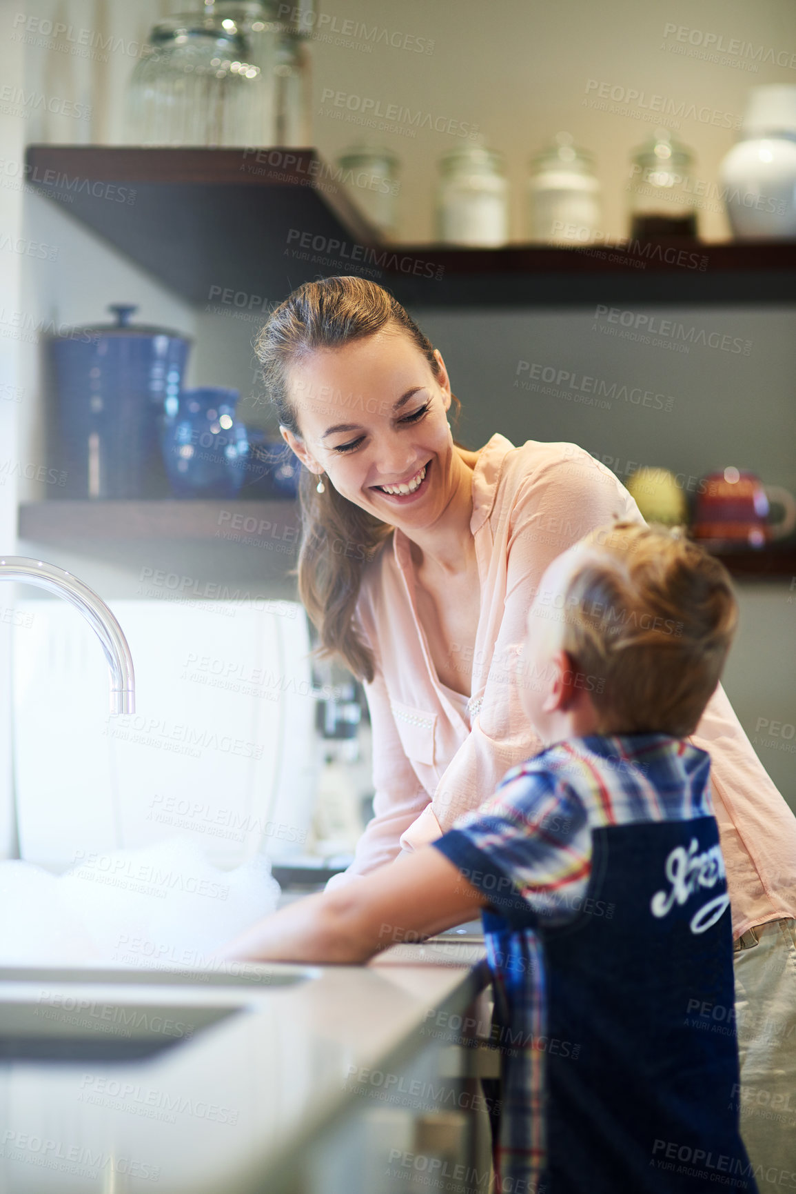 Buy stock photo Shot of a mother and son washing dishes together