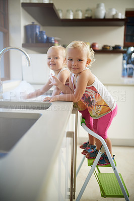 Buy stock photo Portrait, girls and kids with ladder, sink and cleaning in kitchen with fun and activity on weekend break. Face, children and sister with steps and home for chore and cleaning dishes with happiness