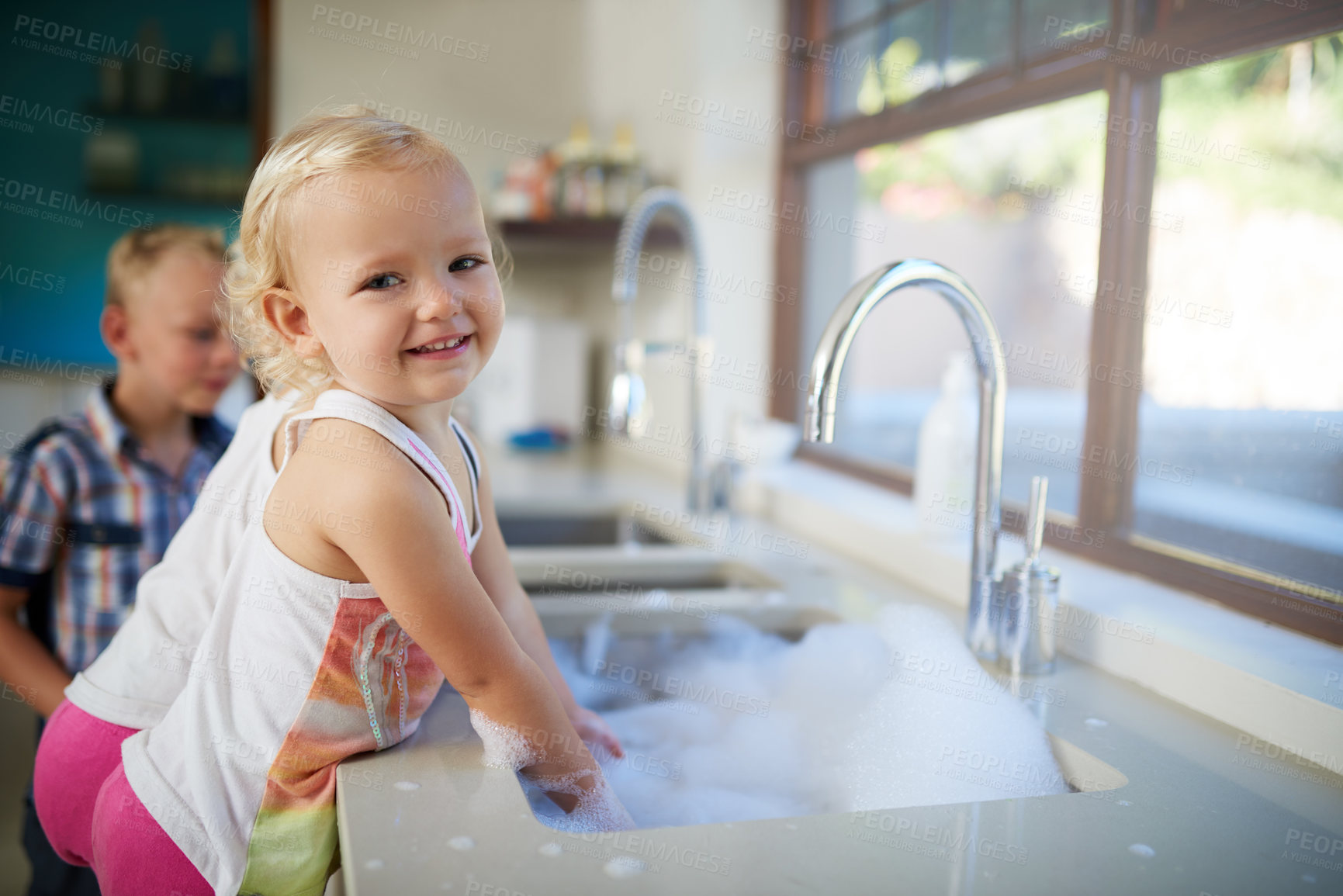 Buy stock photo Portrait, girl and kids with smile, kitchen sink and cleaning dishes in home with fun and activity on weekend break. Face, children and youth with steps and house with joy and learning with happiness