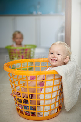 Buy stock photo Happy baby, portrait and laundry basket with sibling for fun childhood, game or chore day at home. Young little girl with smile in clothing bucket for soft hygiene, health and wellness in cleanliness