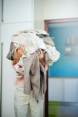 Buy stock photo Shot of a young woman carrying a pile of laundry