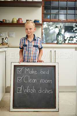Buy stock photo House, chalkboard and portrait of boy with to do list, goal or satisfaction in kitchen. Housework, done and kid at home for learning, accountability and responsibility with fun, note or reminder