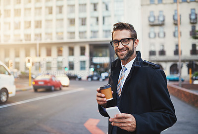 Buy stock photo Shot of a stylish man with coffee and phone in hand while out in the city