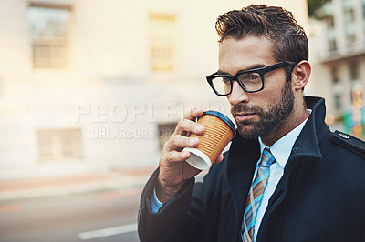 Buy stock photo Shot of a stylish man drinking a cup of coffee while out in the city
