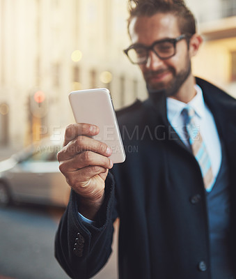 Buy stock photo Shot of a stylish man using his phone in the city