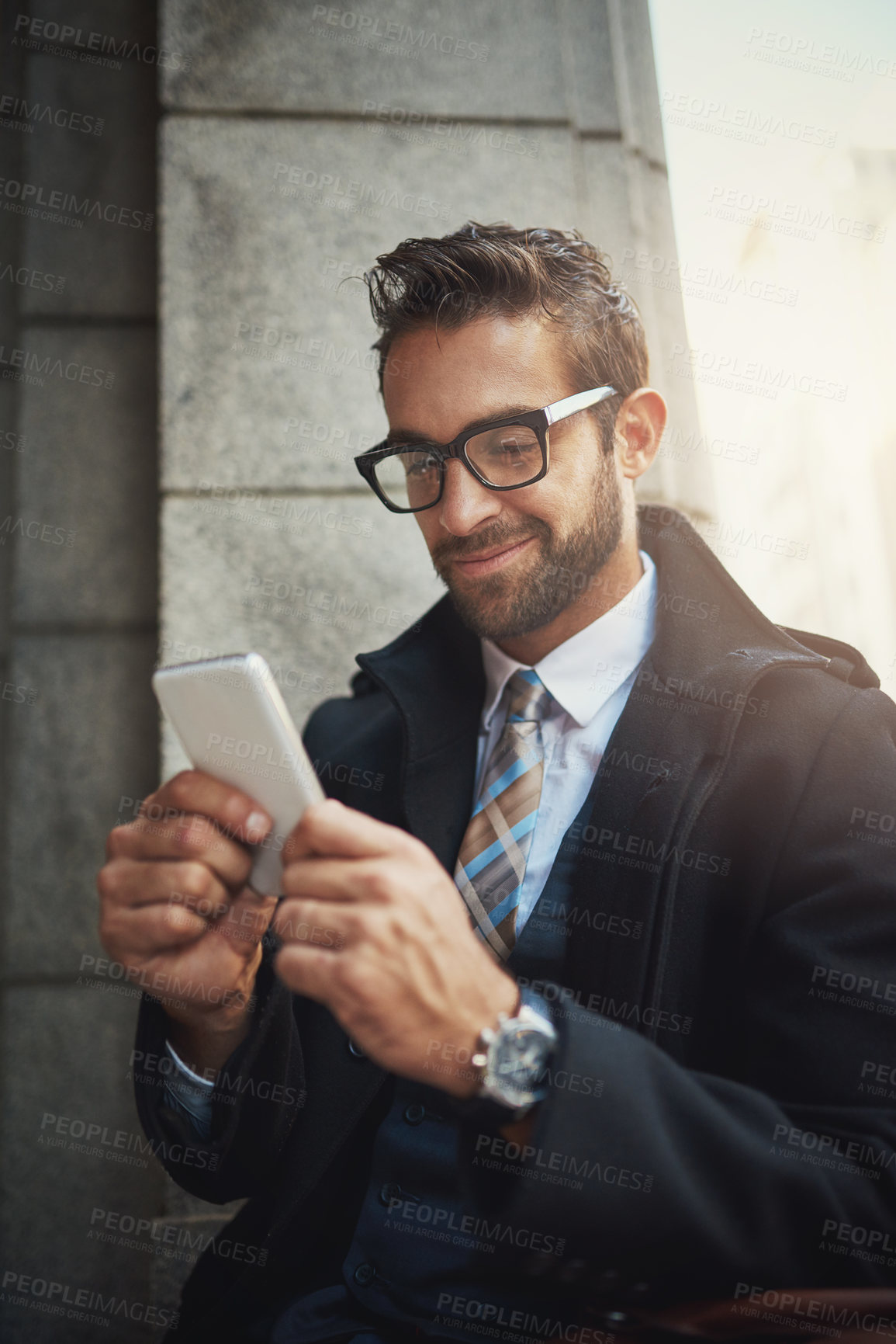 Buy stock photo Shot of a stylish man using his phone in the city