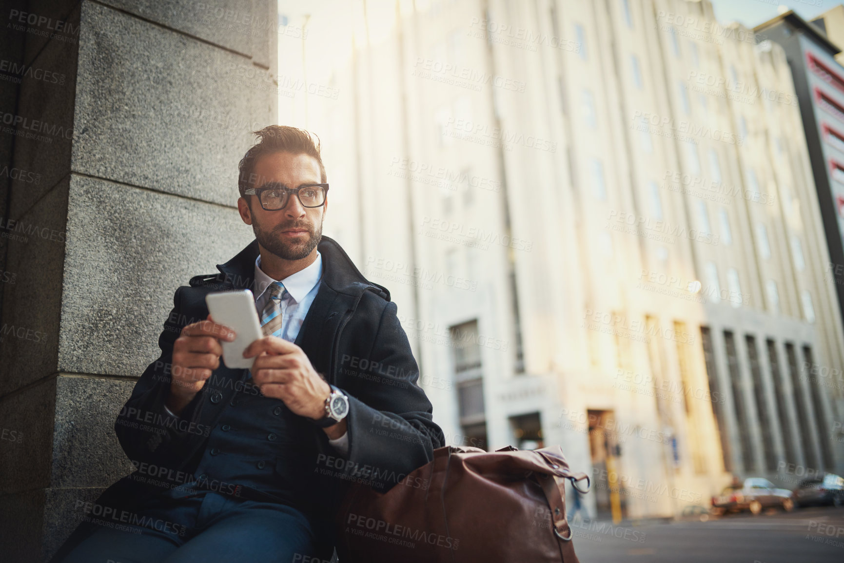 Buy stock photo Shot of a stylish man using his phone in the city