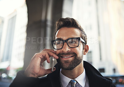 Buy stock photo Shot of a stylish man speaking on his phone in the city