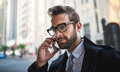 Buy stock photo Shot of a stylish man speaking on his phone in the city