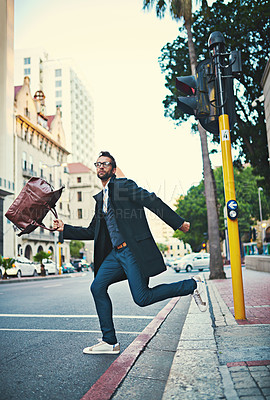 Buy stock photo Shot of a stylish man rushing to cross a city street
