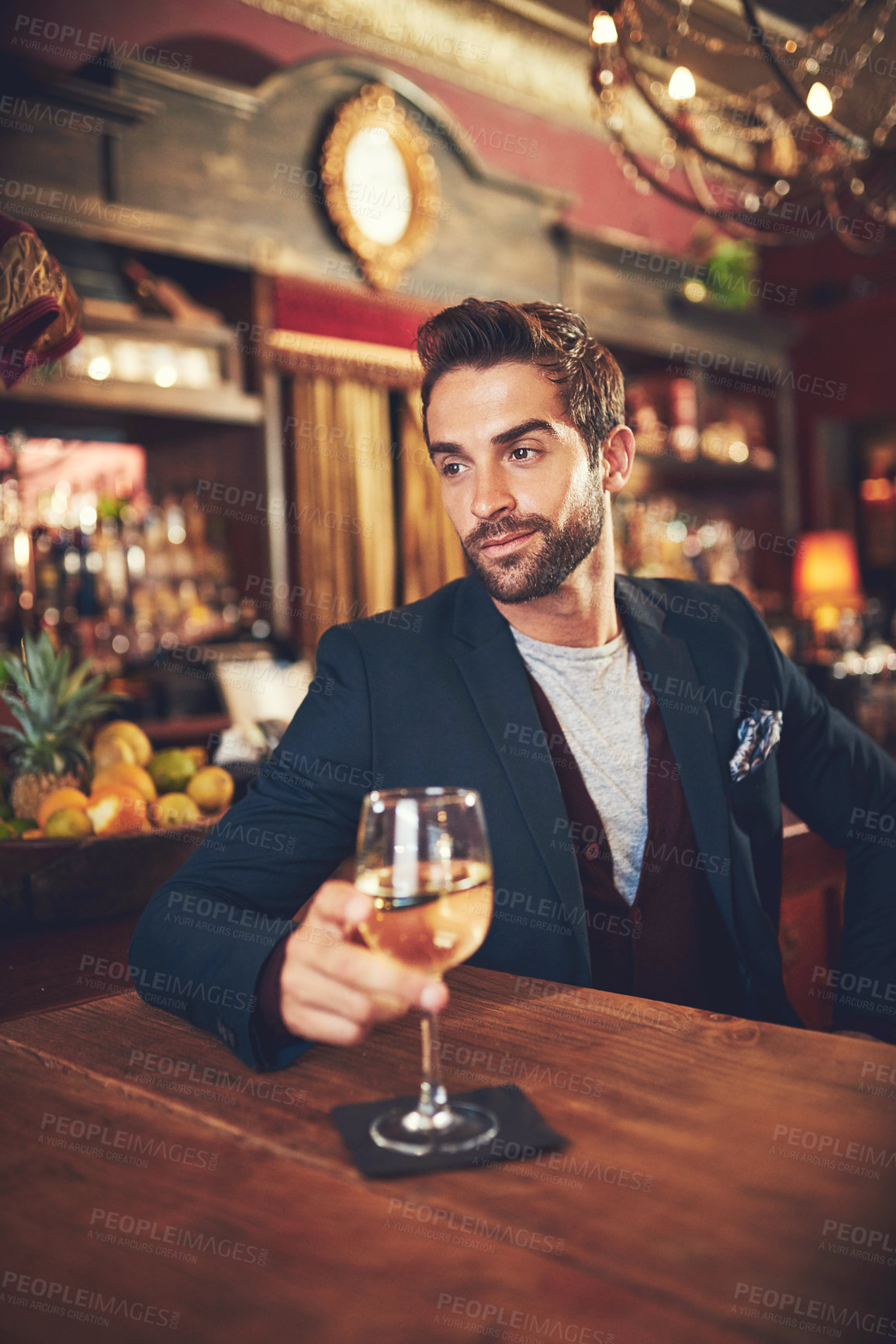 Buy stock photo Cropped shot of a young man sitting in a bar