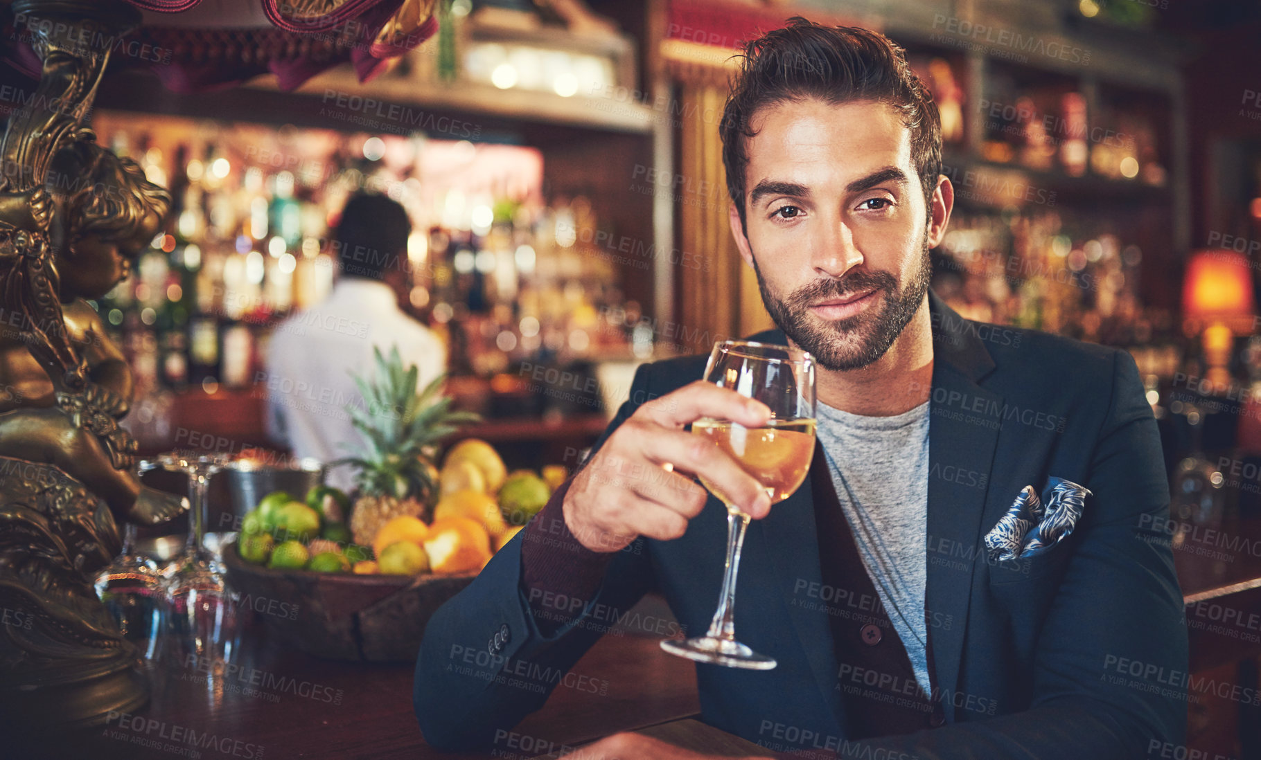 Buy stock photo Cropped shot of a young man sitting in a bar