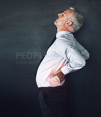 Buy stock photo Studio shot of a mature man experiencing muscular strain