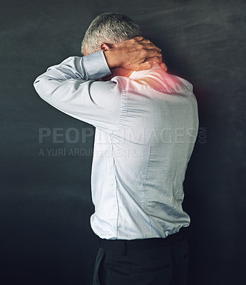 Buy stock photo Studio shot of a mature man experiencing neck ache against a black background