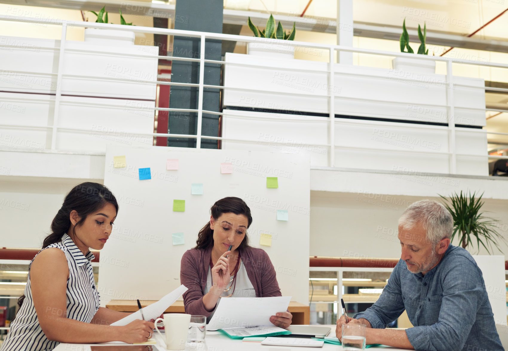 Buy stock photo Shot of a team of colleagues having a meeting in a modern office