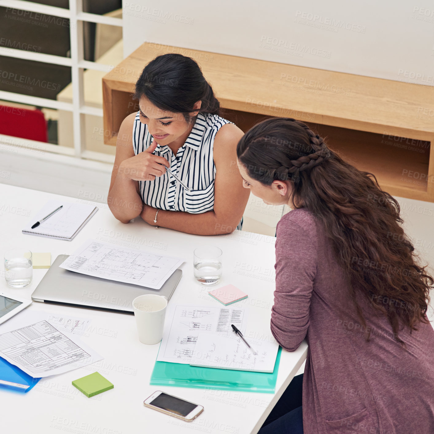 Buy stock photo Shot of a two colleagues having a meeting in a modern office