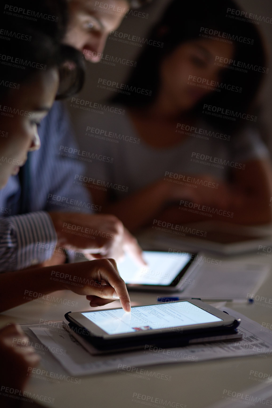 Buy stock photo Shot of a group colleagues using digital tablets while working late in an office