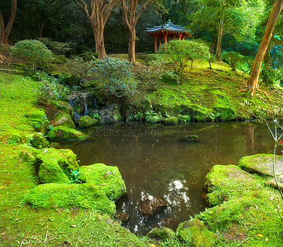 Buy stock photo Mossy garden with a pond and japanese shrine. Landscape of outdoor meditation area in a calm forest. Buddhist prayer temple in a wellness center or spa. Asian pagoda in nature near small serene river