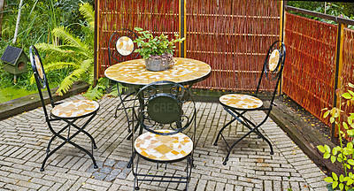 Buy stock photo Garden chairs and table in serene, peaceful private home backyard. Wrought iron metal patio furniture seating in empty, tranquil paved courtyard with fresh plants. Relaxing breakfast spot for reading