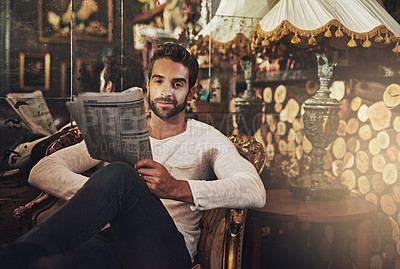 Buy stock photo Portrait of a handsome man reading a newspaper in a cafe