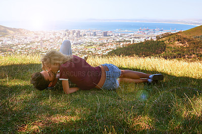 Buy stock photo Couple, relax and kiss in nature for love, romantic date and city view for anniversary. Woman, man and affection on hill with commitment, loyalty and trust in relationship on summer vacation in Italy