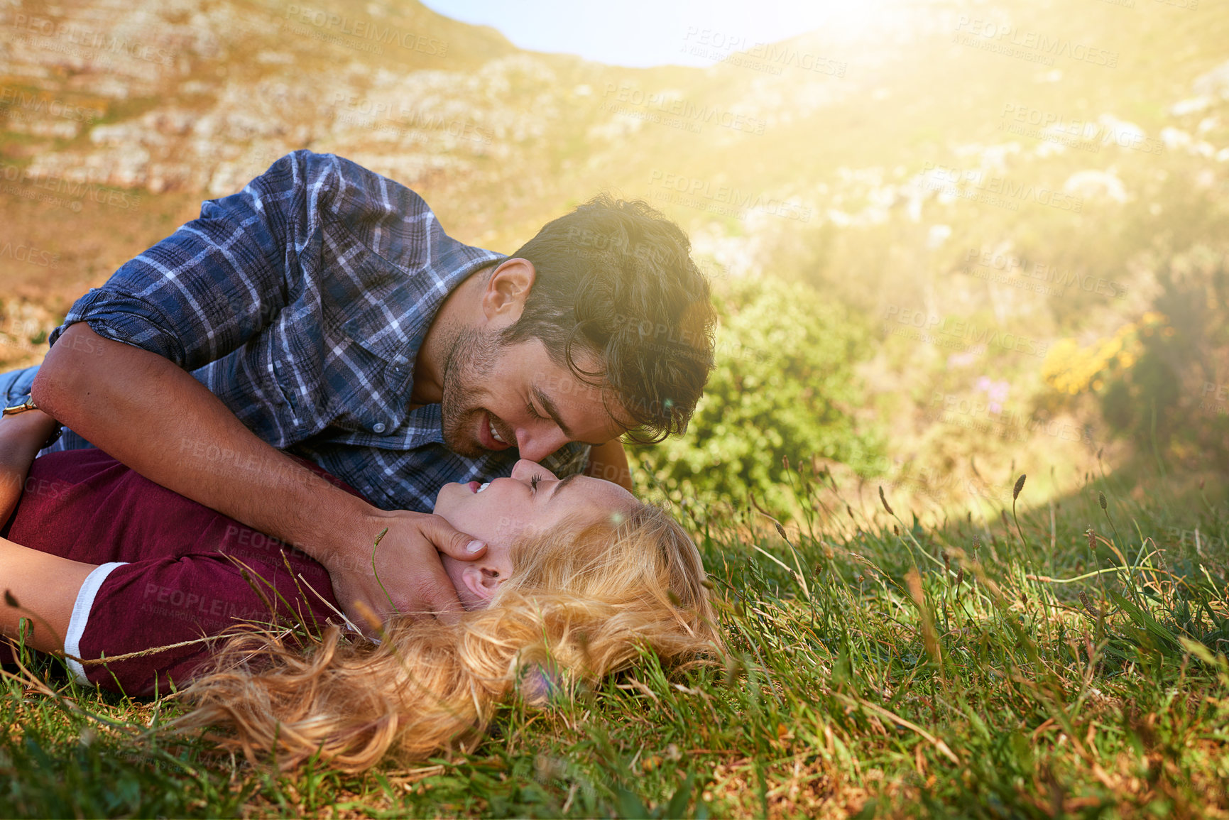 Buy stock photo Shot of an affectionate young couple enjoying a day outdoors