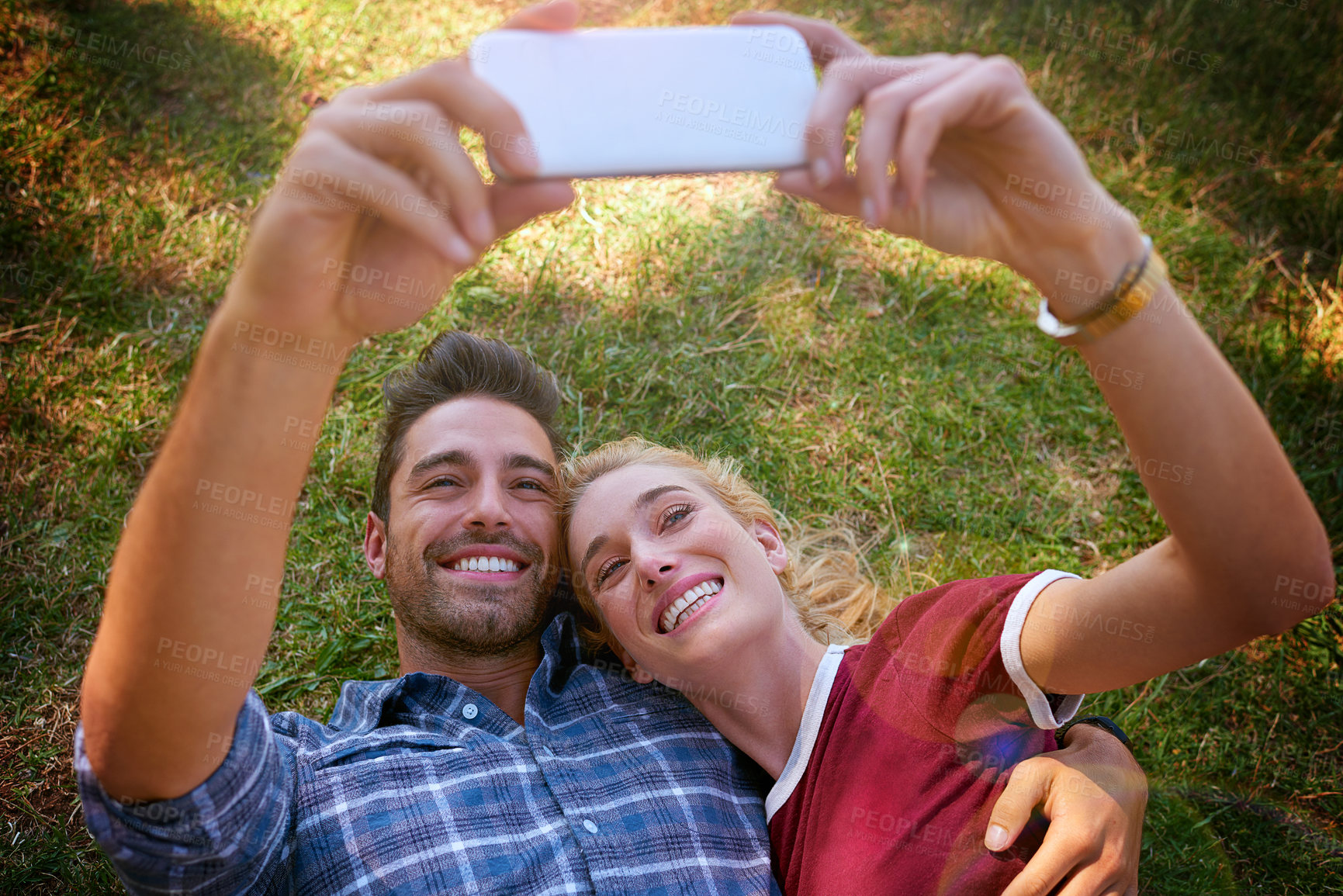 Buy stock photo Happy couple, relax and grass field with selfie for photography, memory or date in nature above. Man, woman or lovers lying with smile for picture moment, capture or social media post at outdoor park