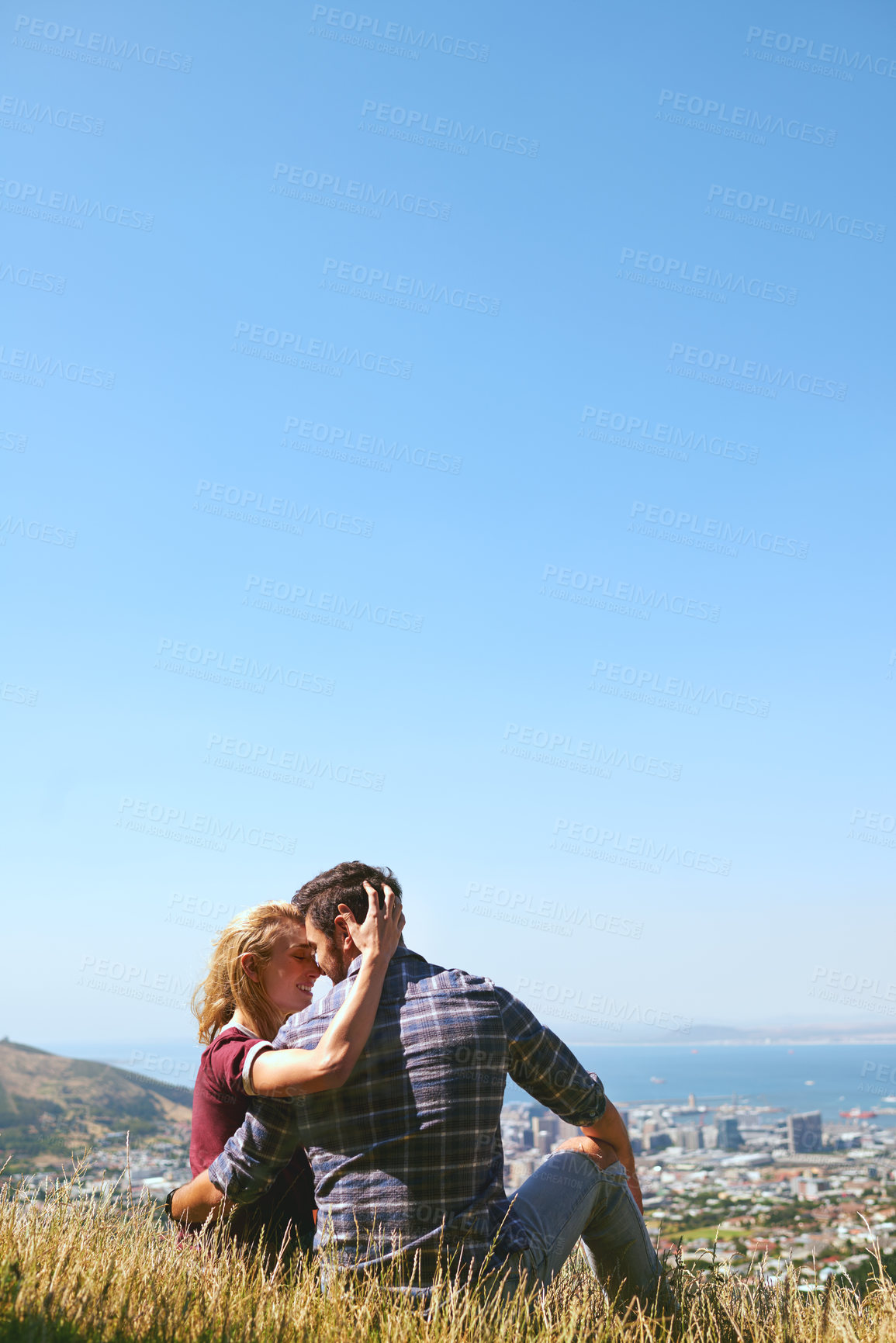 Buy stock photo Shot of an affectionate young couple enjoying a day outdoors