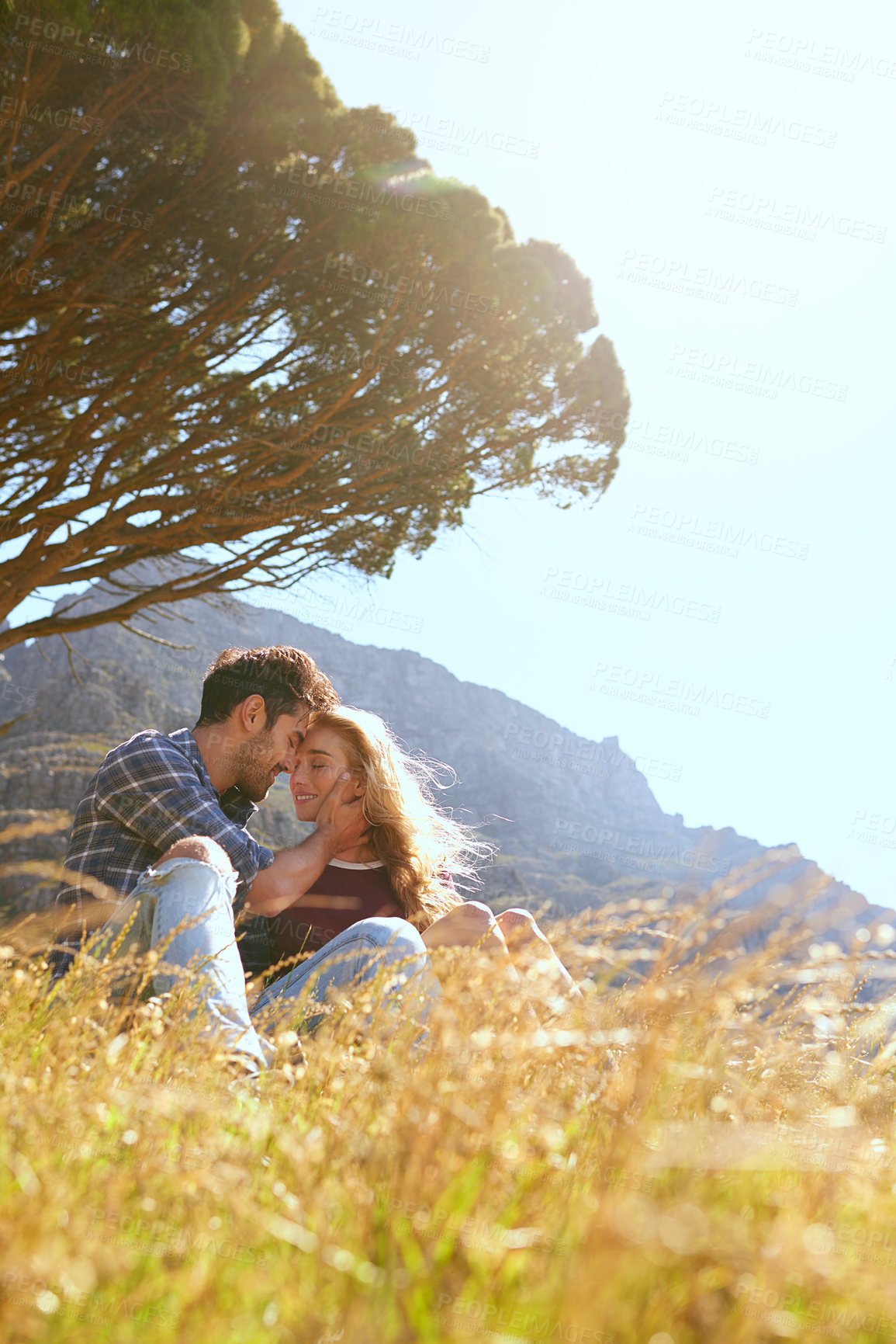 Buy stock photo Shot of an affectionate young couple enjoying a day outdoors