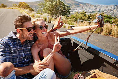 Buy stock photo Shot of a couple taking a selfie while out on a road trip