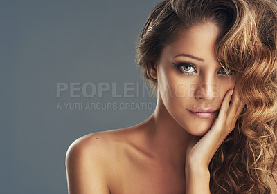 Buy stock photo Cropped shot of a beautiful woman with long brown curls posing against a grey background