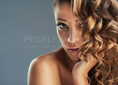 Buy stock photo Cropped shot of a beautiful woman with long brown curls posing against a grey background