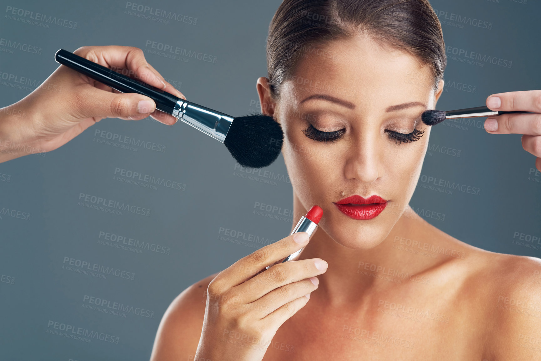 Buy stock photo Makeup artist, model and hands with woman in studio for glamour, cosmetics and cosmetology. Foundation, brush and product with female person on gray background for glow, shine or beauty treatment