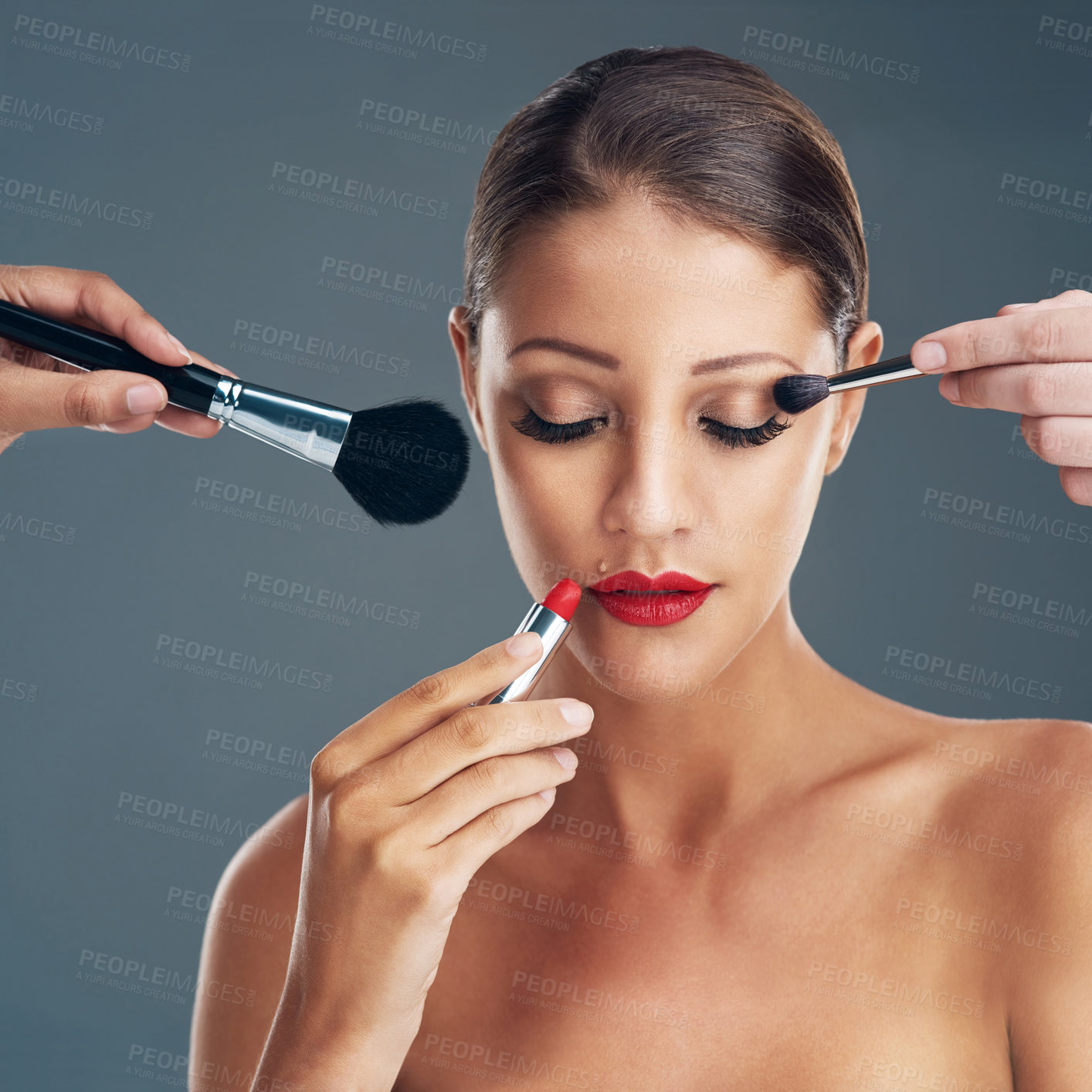 Buy stock photo Studio shot of a beautiful young woman getting her makeup done against a grey background