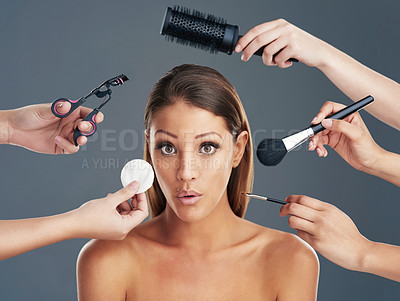 Buy stock photo Portrait shot of a beautiful young woman getting her makeup and hair done against a grey background