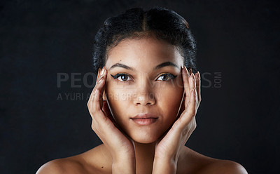 Buy stock photo Shot of a beautiful woman posing against a black background