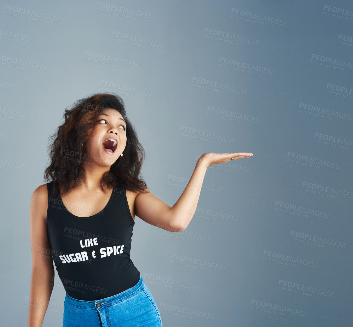 Buy stock photo Happy woman, surprise and palm with mockup space for deal, promotion or offer on a gray studio background. Young, female person or model with hand out for sale notification, alert or advertising 