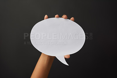 Buy stock photo Shot of a person holding a speech bubble against a dark background