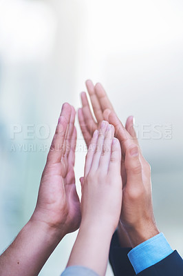 Buy stock photo Shot of a group of people giving each other a high five