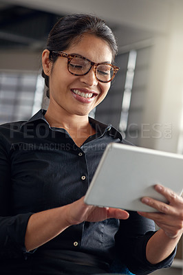 Buy stock photo Shot of a businesswoman using her digital tablet in an office