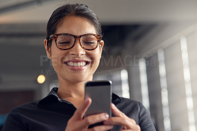 Buy stock photo Shot of a young businesswoman using her cellphone at the office